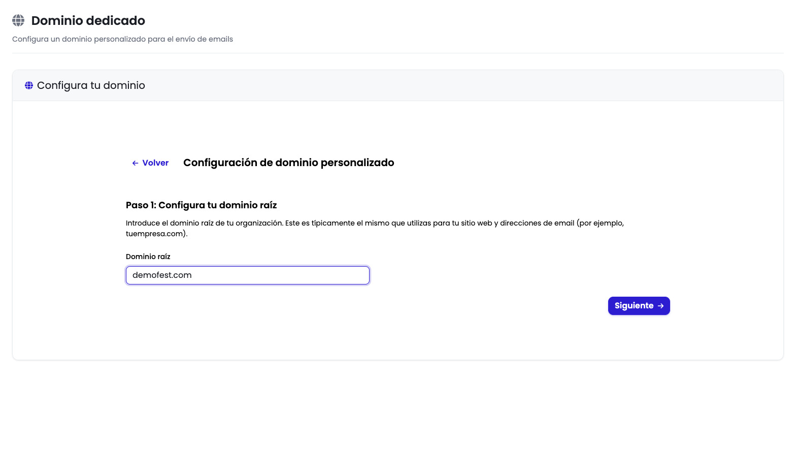 Paso 1 del asistente de dominio dedicado con el campo "Dominio raíz" rellenado con el valor "demofest.com" y el botón "Siguiente" activado
